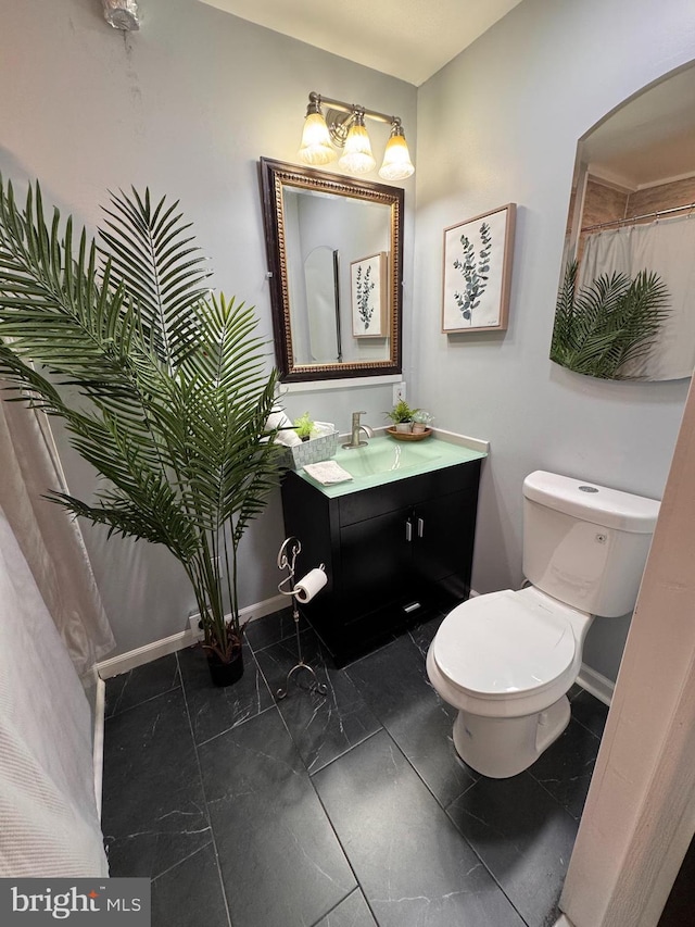 bathroom featuring baseboards, toilet, and vanity