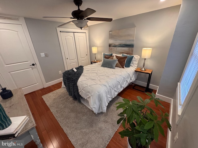 bedroom with a closet, baseboards, dark wood-style floors, and a ceiling fan