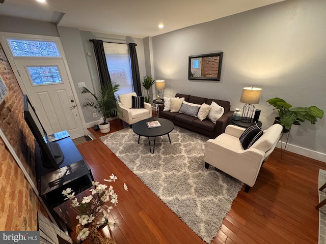 living area featuring baseboards and hardwood / wood-style floors