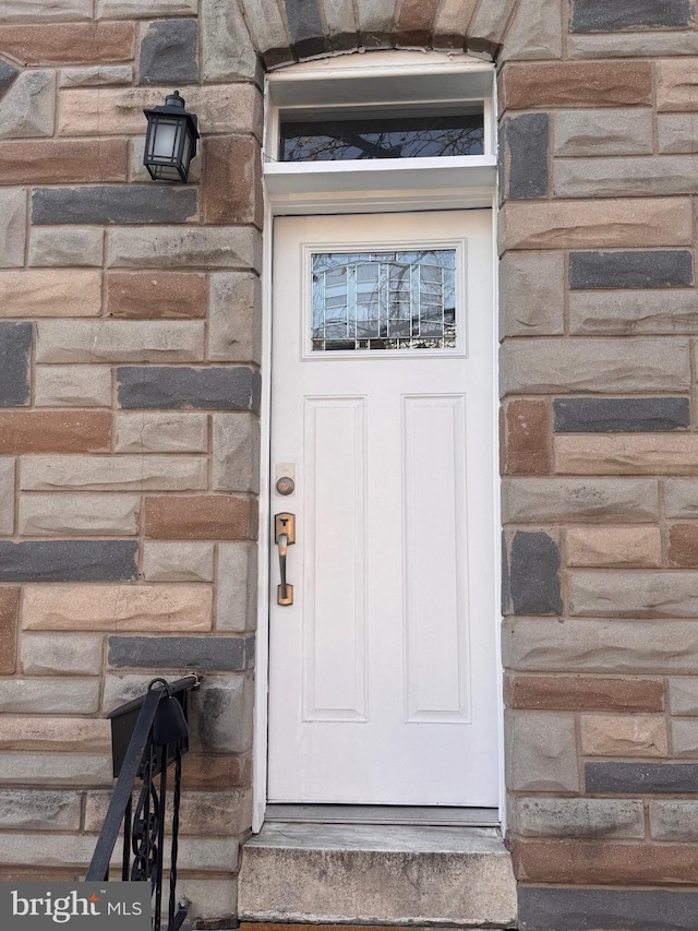 property entrance featuring stone siding