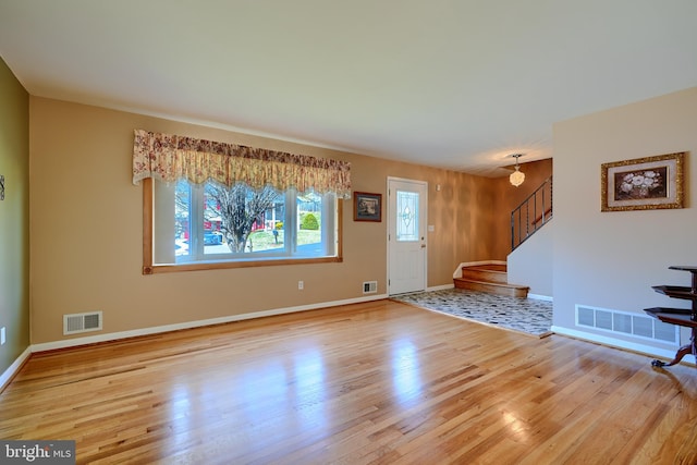 entryway featuring visible vents, wood finished floors, and stairs