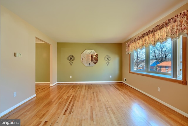 unfurnished room featuring baseboards and wood finished floors