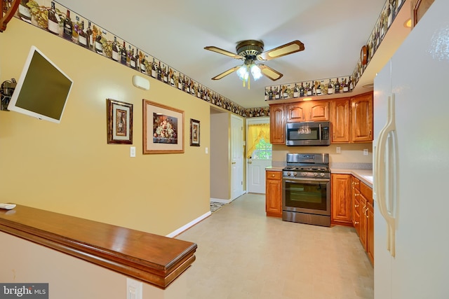 kitchen with brown cabinets, appliances with stainless steel finishes, ceiling fan, and light countertops