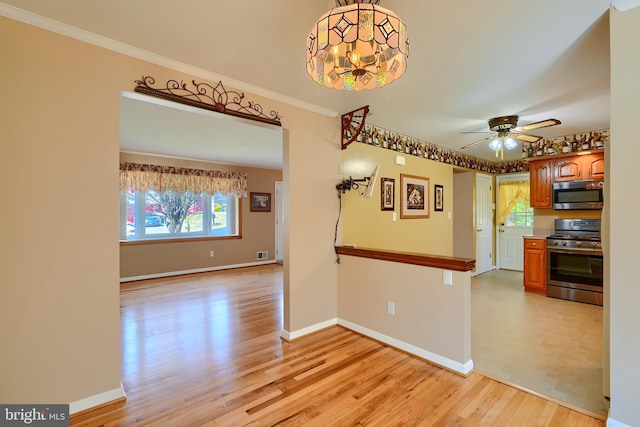 interior space with brown cabinetry, baseboards, ornamental molding, stainless steel appliances, and light wood-type flooring