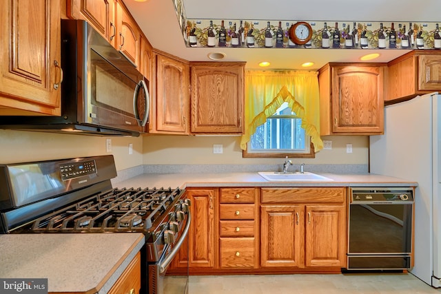 kitchen with a sink, stainless steel range with gas cooktop, dishwasher, and light countertops