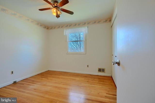 spare room featuring baseboards, visible vents, light wood finished floors, and ceiling fan