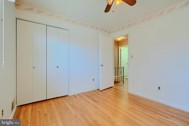 unfurnished bedroom featuring a closet, visible vents, baseboards, and wood finished floors