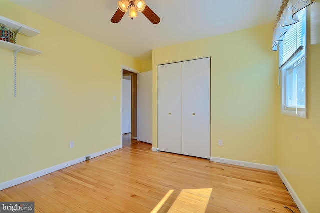 unfurnished bedroom with a closet, baseboards, and light wood-style floors