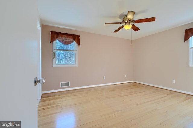 empty room with light wood-type flooring, baseboards, visible vents, and ceiling fan