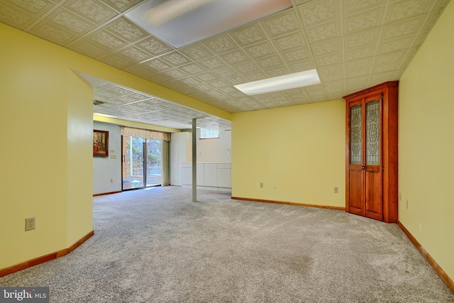 carpeted empty room with baseboards and an ornate ceiling