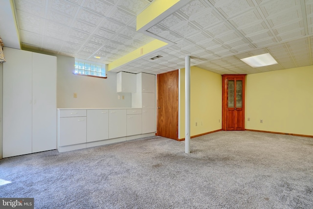 below grade area with carpet flooring, baseboards, and visible vents