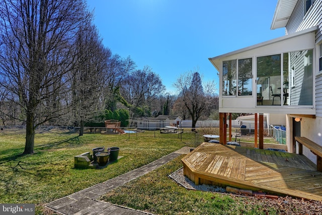 view of yard featuring a deck, fence, and a sunroom