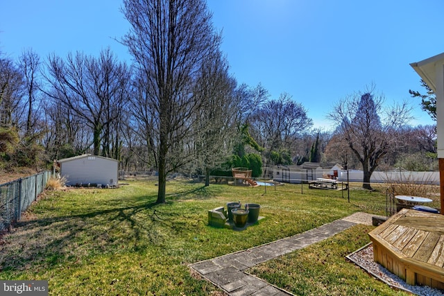 view of yard with an outbuilding, a storage shed, and fence