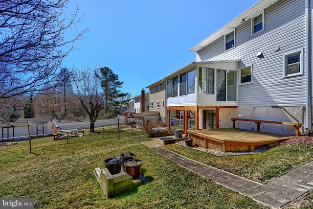 view of yard with a wooden deck, fence, and a sunroom