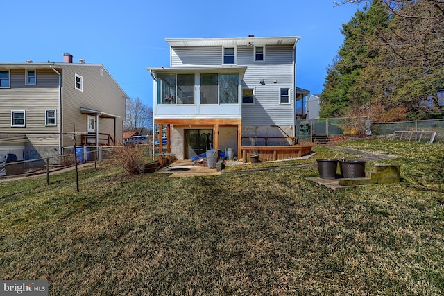 rear view of property featuring a yard, fence, and a sunroom