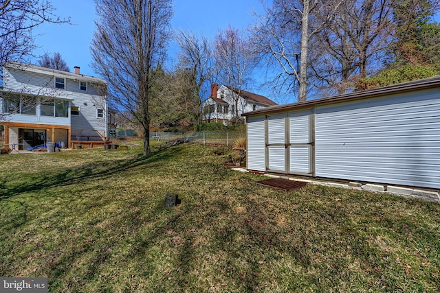 view of yard featuring an outdoor structure, a storage unit, and fence