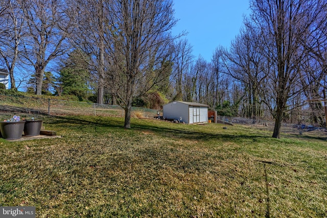 view of yard with an outdoor structure, a shed, and fence