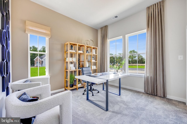 office space with baseboards, visible vents, and a wealth of natural light