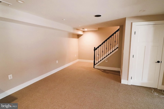 finished below grade area with visible vents, carpet floors, baseboards, and stairs