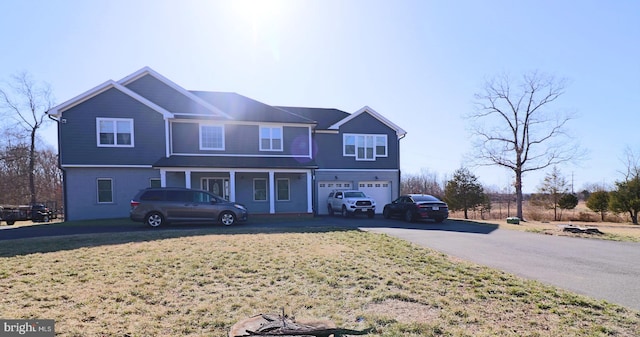 view of front of home featuring a front lawn, a garage, and driveway