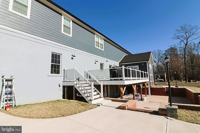 rear view of property with a wooden deck, stairs, and a patio area