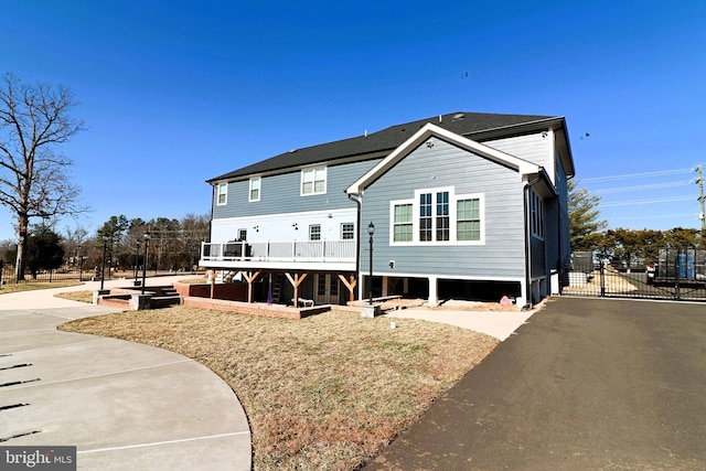 back of property featuring driveway and a gate