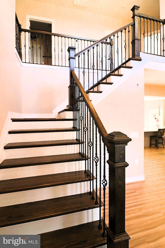 stairs featuring wood finished floors and baseboards