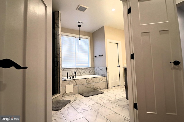 bathroom with a bath, visible vents, and marble finish floor