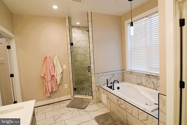 bathroom featuring a garden tub, a wealth of natural light, marble finish floor, and a shower stall