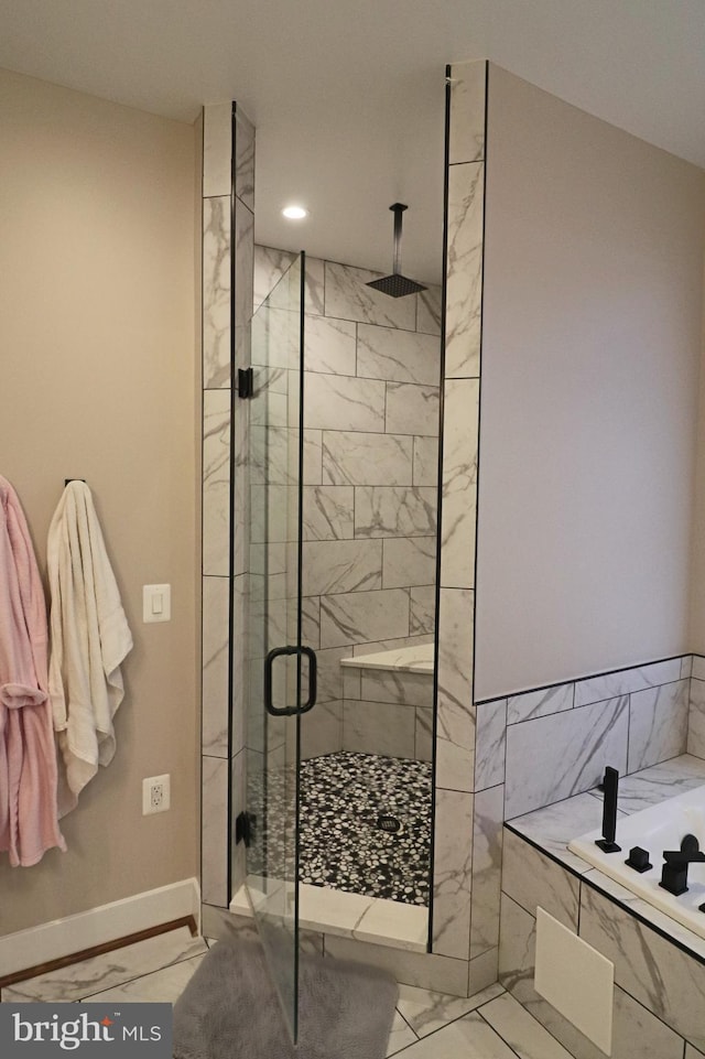 bathroom with marble finish floor, recessed lighting, a shower stall, baseboards, and a bath