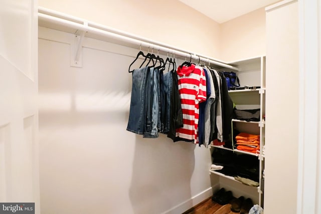 walk in closet with wood finished floors