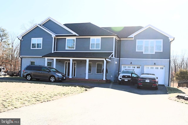 view of front facade with a porch, driveway, and a garage