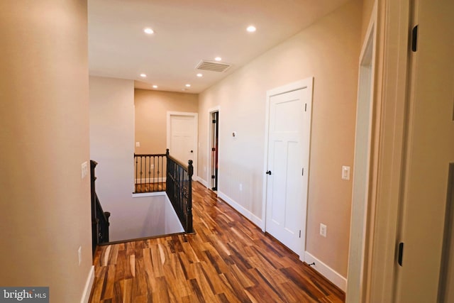 hall featuring visible vents, an upstairs landing, wood finished floors, recessed lighting, and baseboards