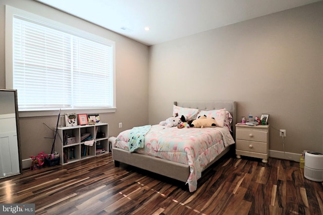 bedroom featuring visible vents, baseboards, and wood finished floors