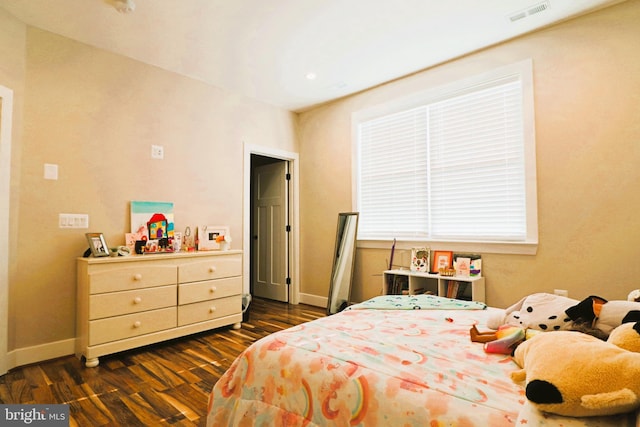 bedroom with visible vents, baseboards, and dark wood-style flooring