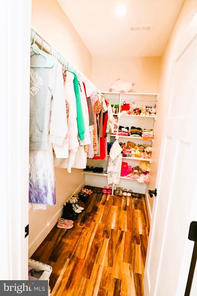 spacious closet featuring wood finished floors and visible vents