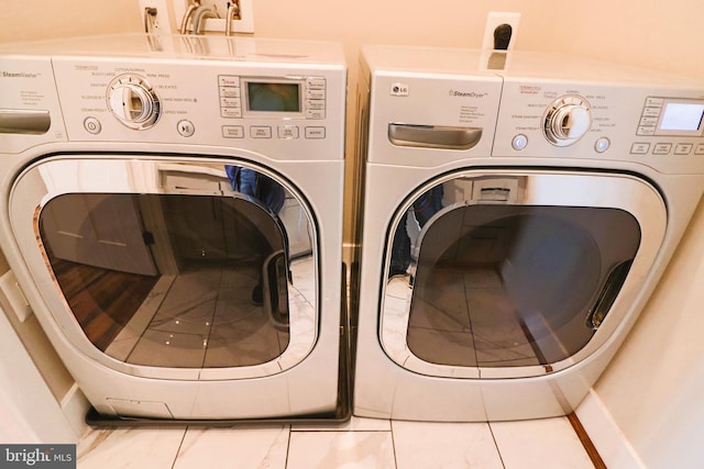 clothes washing area featuring washing machine and clothes dryer and laundry area