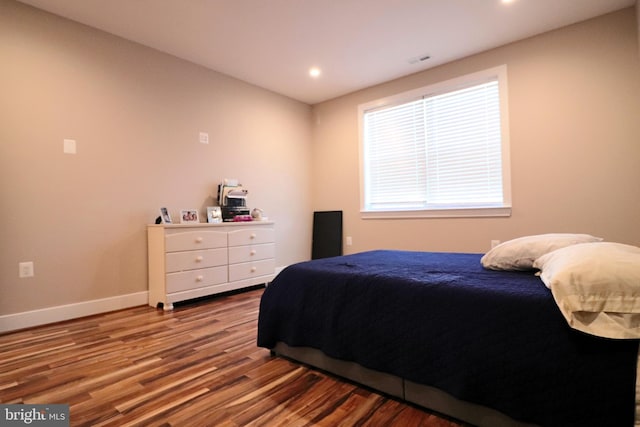 bedroom with recessed lighting, visible vents, baseboards, and wood finished floors