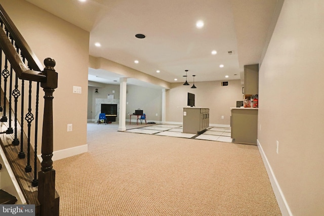 interior space featuring a glass covered fireplace, recessed lighting, light colored carpet, and baseboards