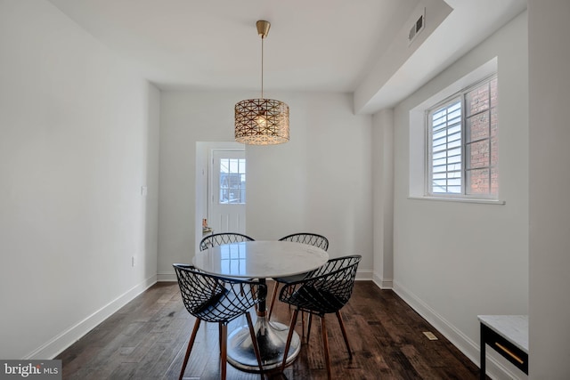 dining area with dark wood finished floors, a healthy amount of sunlight, and visible vents