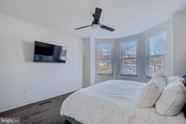 bedroom featuring visible vents, multiple windows, dark wood-type flooring, and baseboards