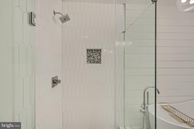 full bathroom with a soaking tub and a tile shower