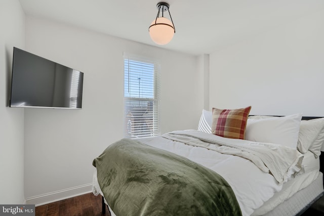 bedroom featuring baseboards and wood finished floors