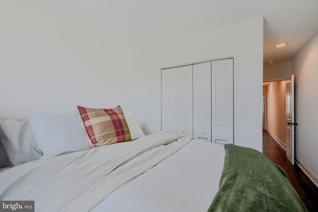 bedroom with recessed lighting, dark wood-style floors, a closet, and baseboards