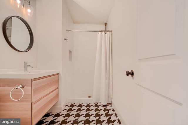 full bathroom with vanity, a shower with shower curtain, and baseboards