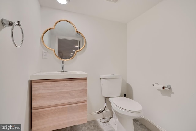 bathroom with visible vents, baseboards, toilet, wood finished floors, and vanity