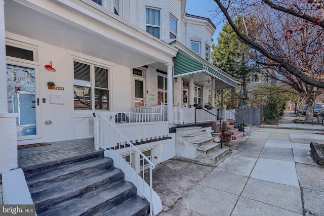 view of exterior entry featuring covered porch