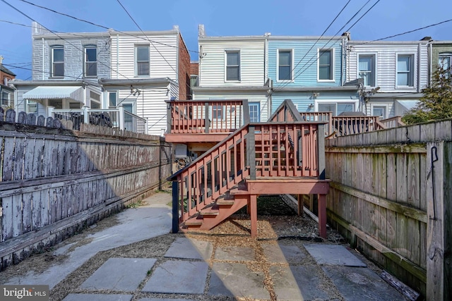 rear view of house with a wooden deck and fence