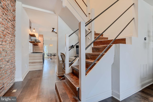 staircase with visible vents, baseboards, and hardwood / wood-style floors