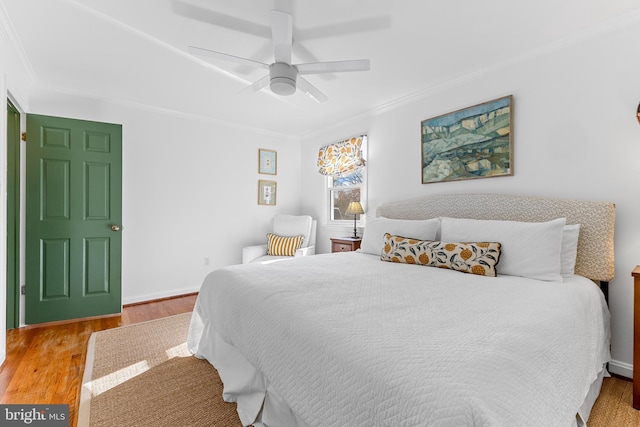 bedroom with crown molding, ceiling fan, and wood finished floors